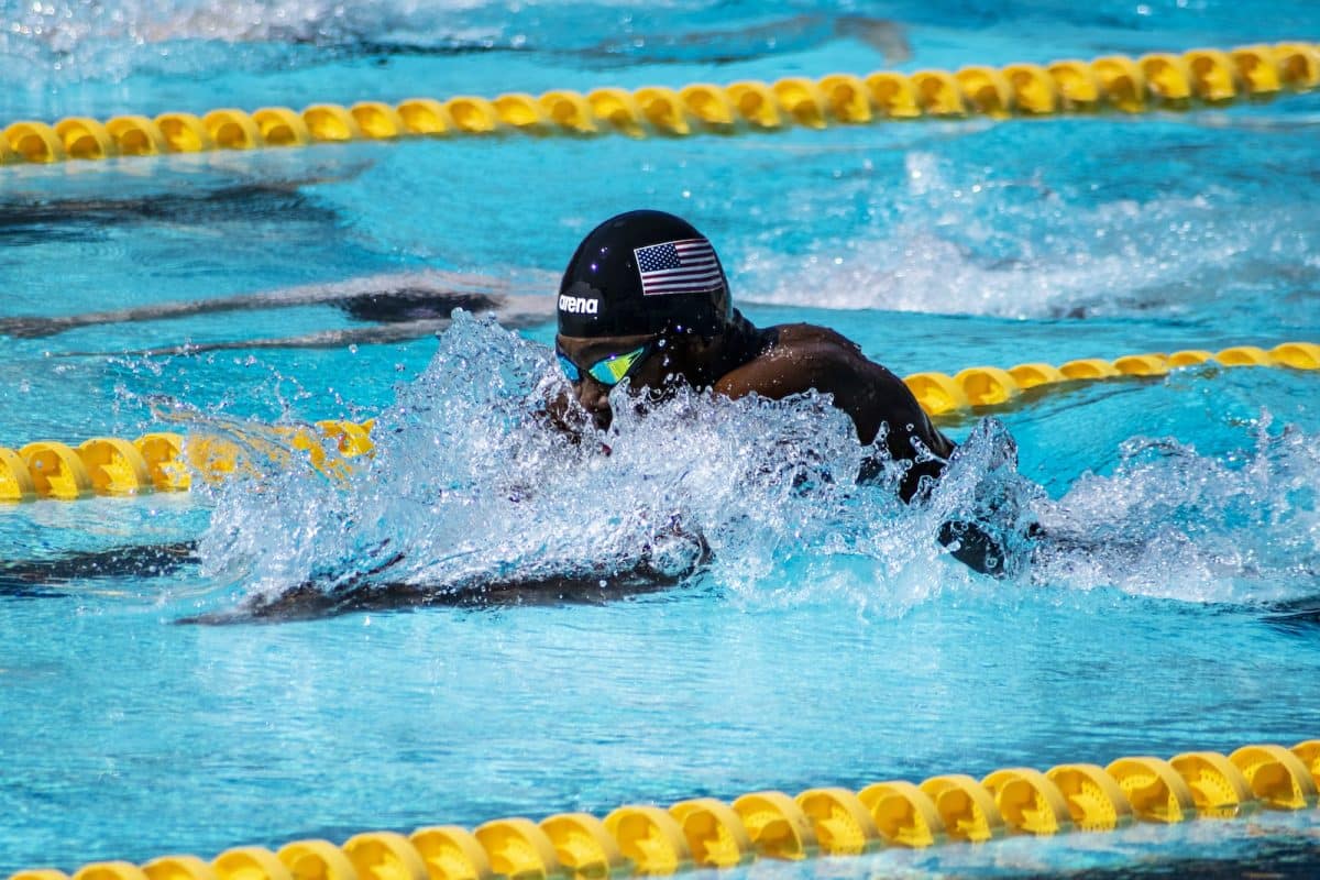a person swimming in a pool with a helmet on