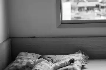 grayscale photo of person lying on bed